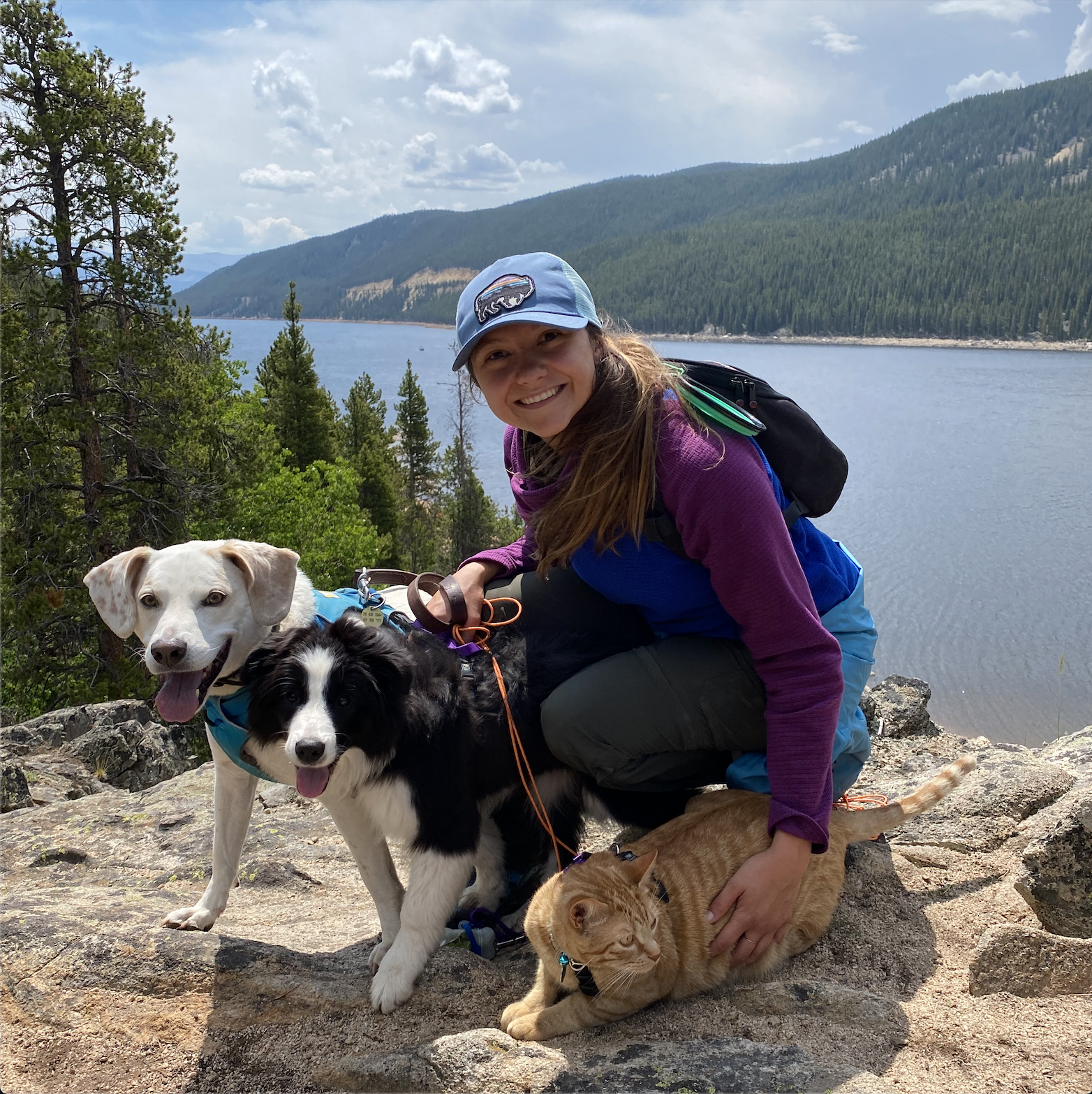 Bio picture of Olivia at an alpine lake with her three animals.